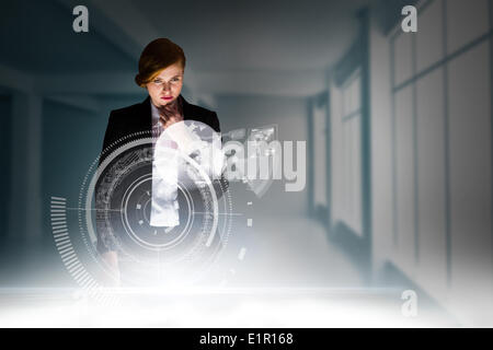 Composite image of redhead businesswoman using interactive desk Stock Photo