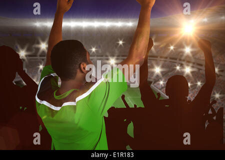 Composite image of cheering football fan in green jersey Stock Photo