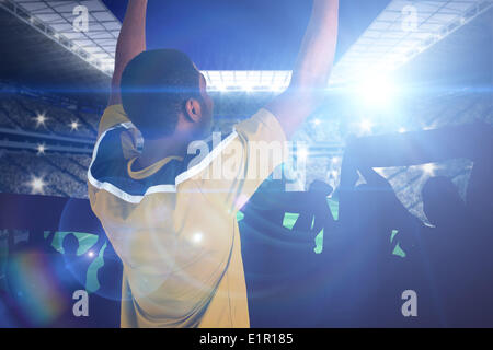 Composite image of cheering football fan in yellow jersey Stock Photo