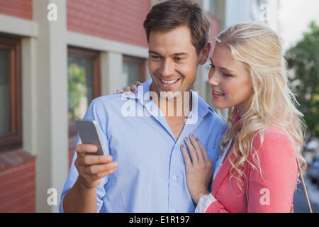 Stylish young couple looking at smartphone Stock Photo