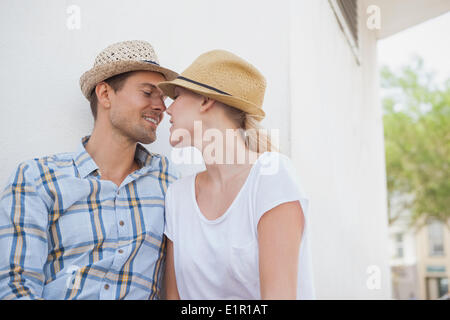 Young hip couple sitting on bench about to kiss Stock Photo