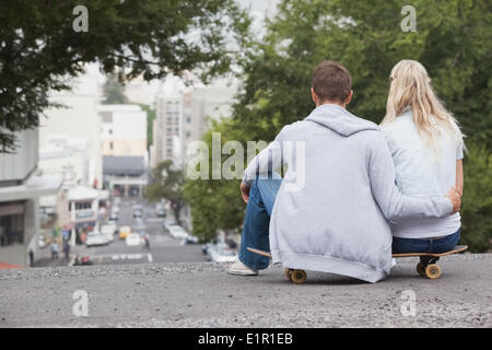 Cute young couple sitting on skateboard Stock Photo