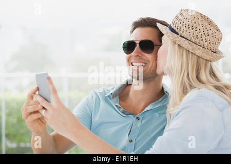 Cute couple sitting in cafe taking a selfie Stock Photo