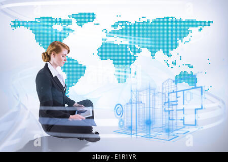 Composite image of redhead businesswoman using her tablet pc Stock Photo