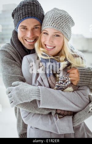Cute couple in warm clothing hugging smiling at camera Stock Photo - Alamy