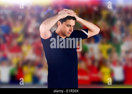 Composite image of disappointed football player looking down Stock Photo