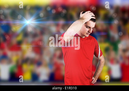 Composite image of disappointed football player looking down Stock Photo