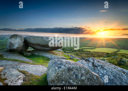 Sunset over giant granite boulders at Helman Tor a rugged area of moor near Bodmin in Cornwall Stock Photo