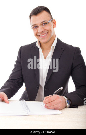 handsome businessman with glasses writing in notebook smiling Stock Photo