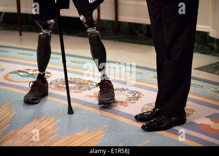 US President Barack Obama stands with a rider from the Wounded Warrior Project Soldier Ride in the Diplomatic Reception Room of the White House April 17, 2014 in Washington, DC. Stock Photo