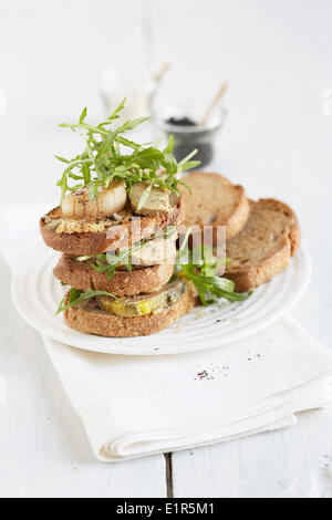 Foie gras and scallops on toasts Stock Photo