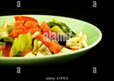 Close up vegetable boiled consisting of cabbage, carrots, tofu and capsicum on black background. Stock Photo