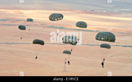 Paratroopers from various countries descend over the desert during a parachute jump as part of Exercise Eager Lion June 2, 2014 in Jebel Petra, Jordan. Stock Photo