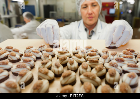 Workers at the Swiss chocolate factory of Lindt & Spruengli in Zurich / Kilchberg are sorting and packaging chocolate candies. Stock Photo