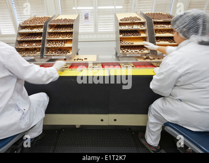 Workers at the Swiss chocolate factory of Lindt & Spruengli in Zurich / Kilchberg are sorting and packaging chocolate candies. Stock Photo