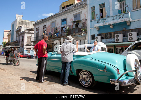 People and classic american cars in the streets of Havana, Cuba Stock Photo