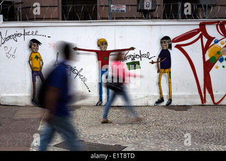 Sao Paulo, Brazil. 9th June, 2014. People walk in front of a painted wall in downtown Sao Paulo, Brazil, on June 9, 2014. The 2014 FIFA World Cup will be held in Brazil from June 12 to July 13. Credit:  Guillermo Arias/Xinhua/Alamy Live News Stock Photo