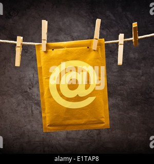 Postal mail Envelope with monkey sign hanging on rope attached with clothes pins. Communication concept. Stock Photo