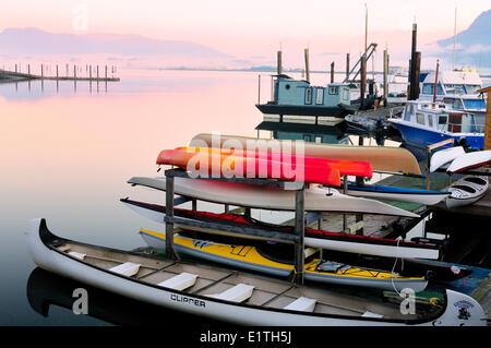 Docks, canoes, kayaks and float homes sit idle at a marina in Cowichan Bay, BC. Stock Photo