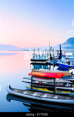 Docks, canoes, kayaks and float homes sit idle at a marina in Cowichan Bay, BC. Stock Photo