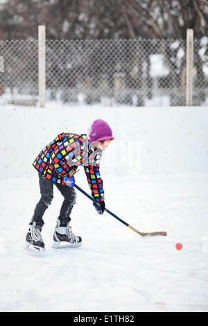 Boy playing ice hockey on an outdoor rink, Winnipeg, Manitoba, Canada Stock Photo