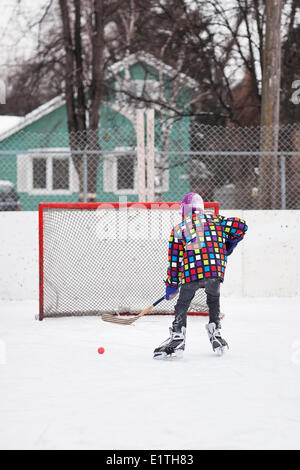 Boy playing ice hockey, on an outdoor neighborhood rink, Winnipeg, Manitoba, Canada Stock Photo