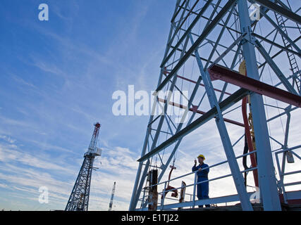 Drilling rig worker talking on radio on platform. Stock Photo