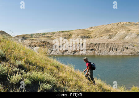 hiker, South Saskatchewan River Valley with Lake Diefenbaker in the background, near Beechy,  Saskatchewan, Canada Stock Photo