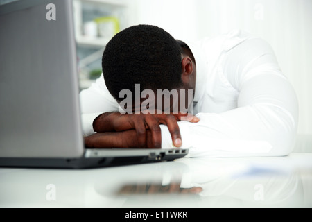 African man sleeping at his workplace in office Stock Photo