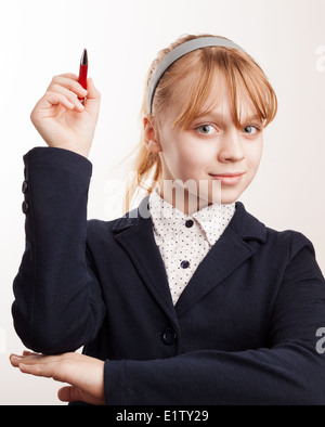 Little blond schoolgirl holds up the pen Stock Photo