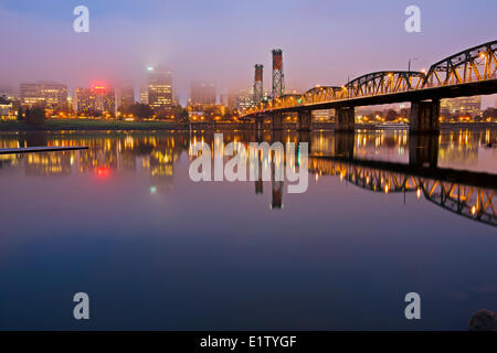 Portland city skyline at dawn in fog early morning with Hawthorne Bridge the city waterfront reflecting in the Willamette River Stock Photo