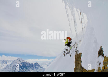A man drops a cliff while backcountry skiing in the Canadian Rockies. Icefall Lodge, Golden, BC Stock Photo