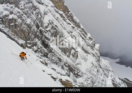 A male backcountry telemark skier heads down a steep couloir in Spray Lakes, Kananaskis, near Canmore AB Stock Photo