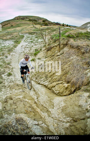 A male mountain biker enjoys a muddy section  of the Maah Daah Hey Trail, North Dakota Stock Photo