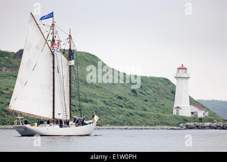 Tall ship Bowdoin sails past the lighthouse on George's Island in Halifax Harbour during the Parade Sail conclusion to the 2007 Stock Photo