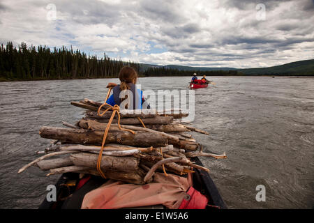 Canoeing with gathered firewood on Nahanni River, Nahanni National Park Preserve, NWT, Canada. Stock Photo