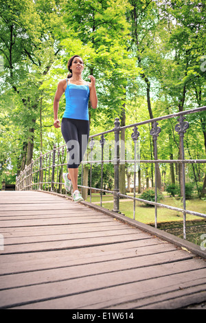 woman jogging by a river in the old city park Stock Photo