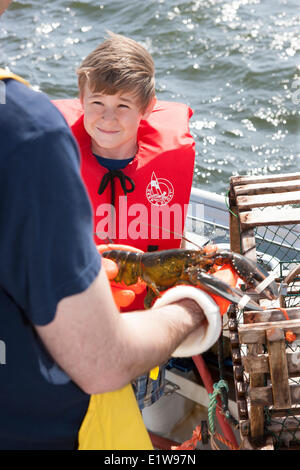 Young boy talking to Lobster fisherman, Northport, Prince Edward Island, Canada Stock Photo