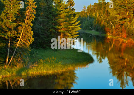 Sun setting on water at Reed Narrows, connected to Lake of the Woods, Sioux Narrows, Ontario, Canada Stock Photo