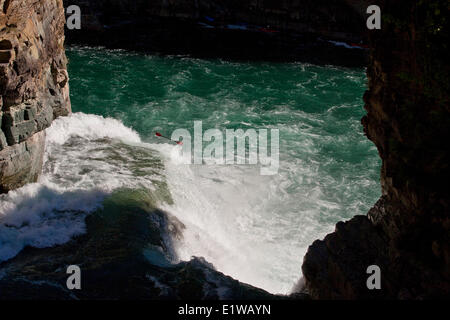 A male kayaker runs leap of faith, a 30 foot waterfall on the Upper Elk River, Fernie, BC Stock Photo