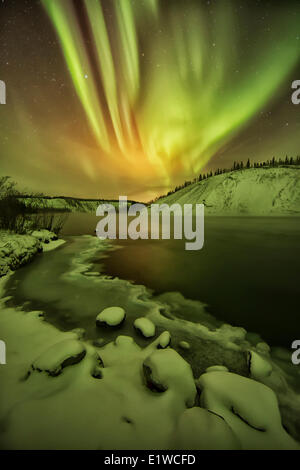 Aurora borealis light up the night sky over the Yukon River in the Yukon. Also known as the northern lights. Stock Photo