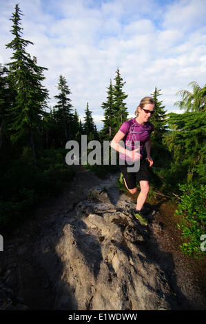 Female trail running on the Cabin Lake Trail on Black Mountain. Cypress Provincial Park. West Vancouver British Columbia Canada Stock Photo