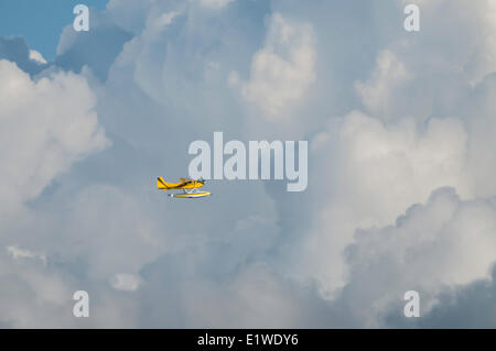 Float plane flying in the clouds. Stock Photo