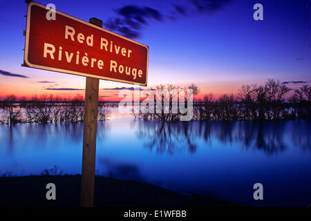Signage along the Red River with spring river flooding in the background, near St. Adolphe, Manitoba Stock Photo