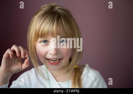 Portrait of smiling little girl showing her first loose tooth Stock Photo