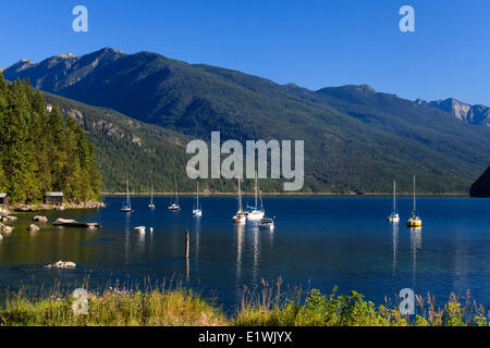 Boats floating on Slocan Lake with the Valhalla Range in the background, near Slocan, British Columbia Stock Photo