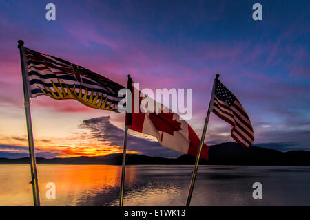 Flags at sunset over looking ocean Stock Photo