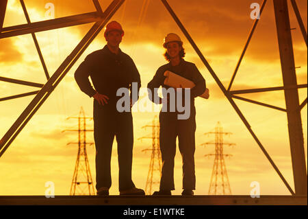 workers on an electrical tower, pylon, Manitoba, Canada Stock Photo