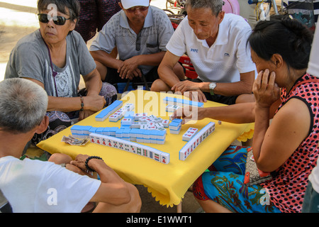 Some old people playing mahjong on the summer beach. Stock Photo