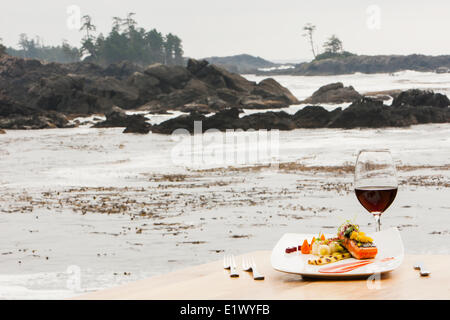 A single serving Salmon main course with accompanying red wine overlooks the ocean swells surrounding the Black Rock Resort in Stock Photo